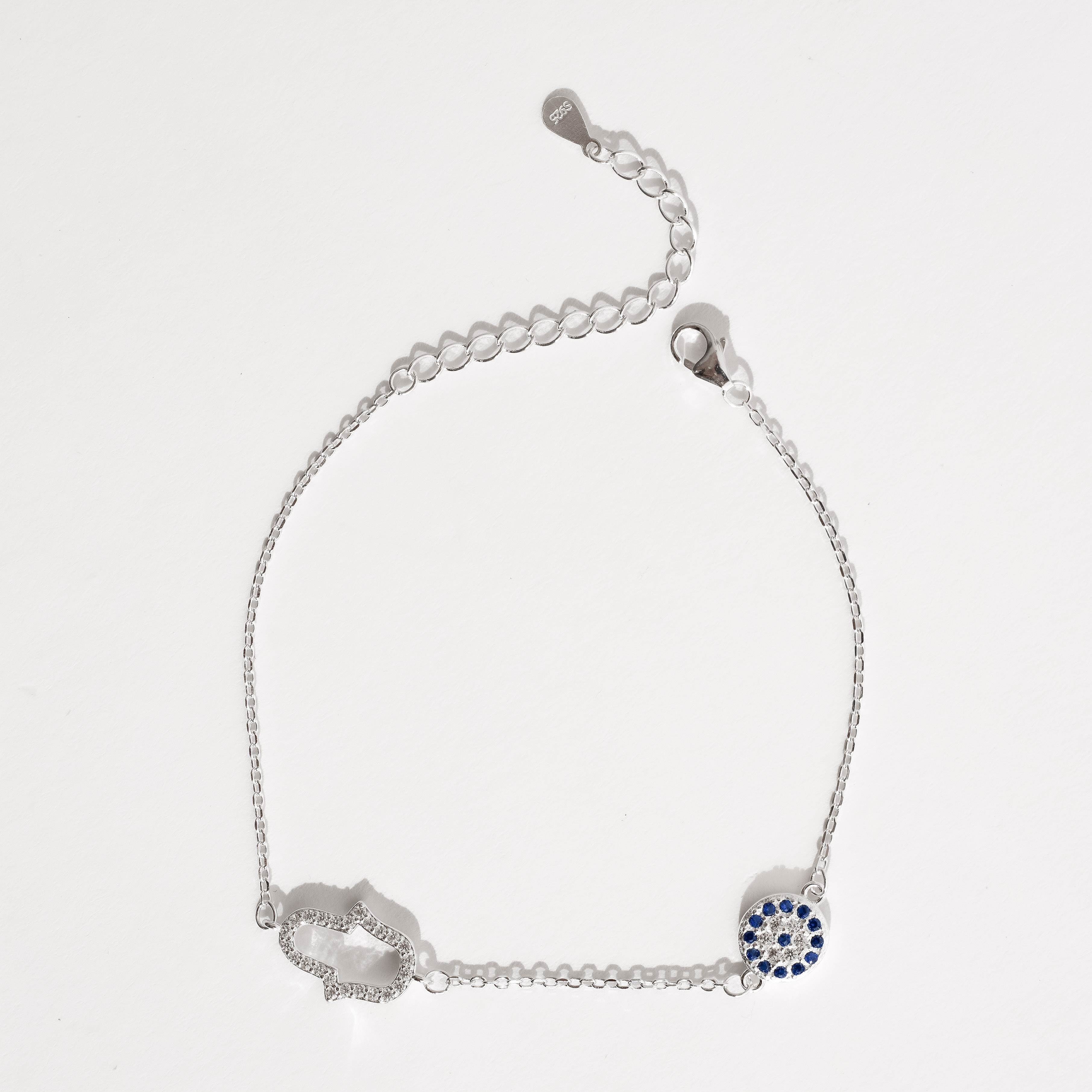 Pulseira entremeios mão vazada e olho grego cravejados